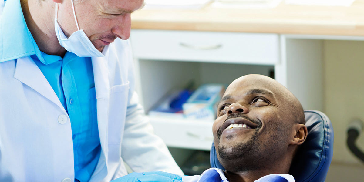 Doctor speaking with patient in dental chair